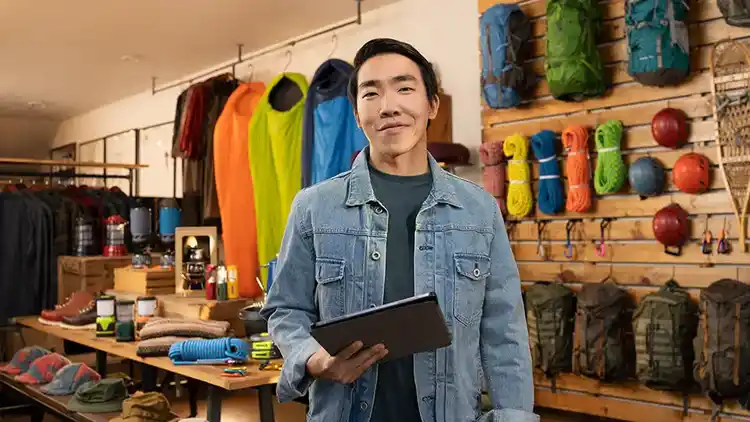 Un homme tenant une tablette dans un magasin de sport