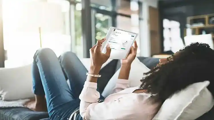 Mujer en un sofá viendo una iPad